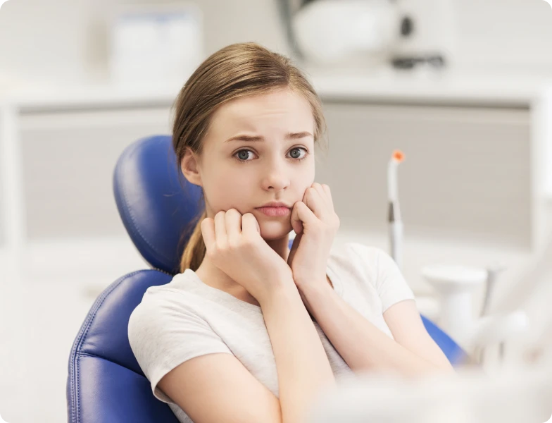 Patiente anxieuse assise dans un fauteuil de soins dentaires